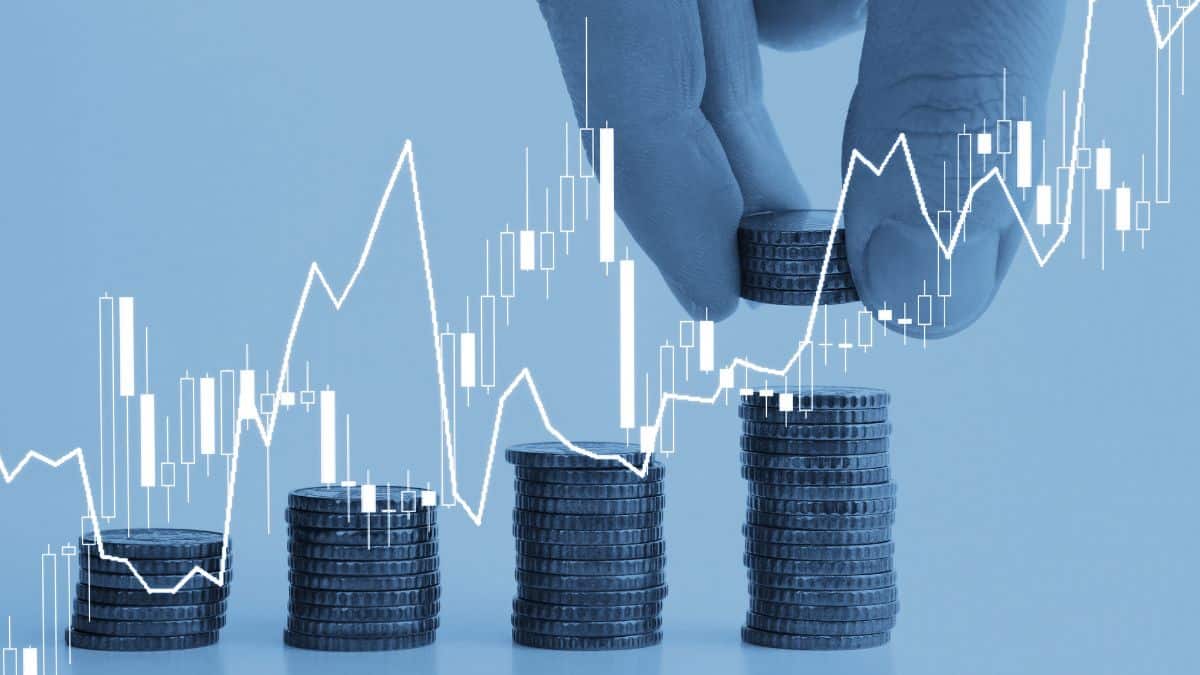 a hand stacking coins with graph