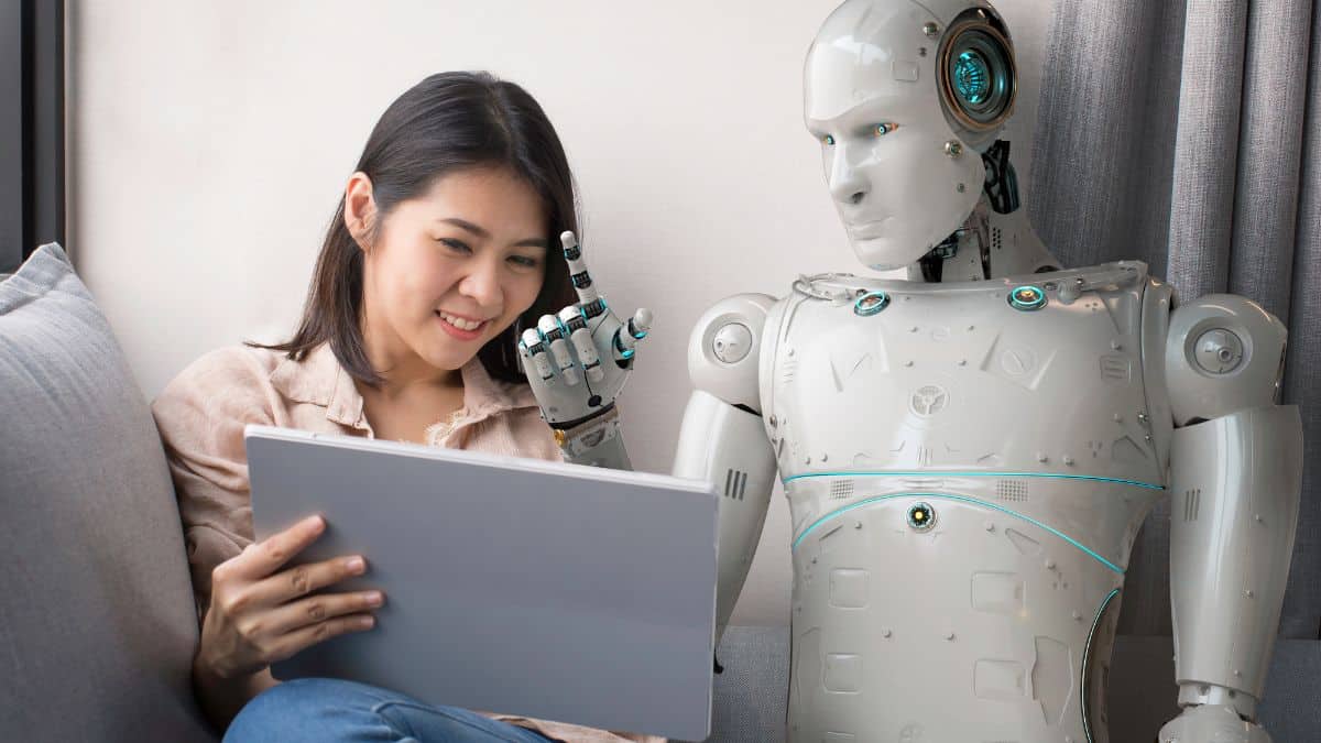a woman holding a tablet next to a robot
